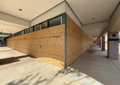 Multiple vacant retail storefronts secured with commercial board-up services.
